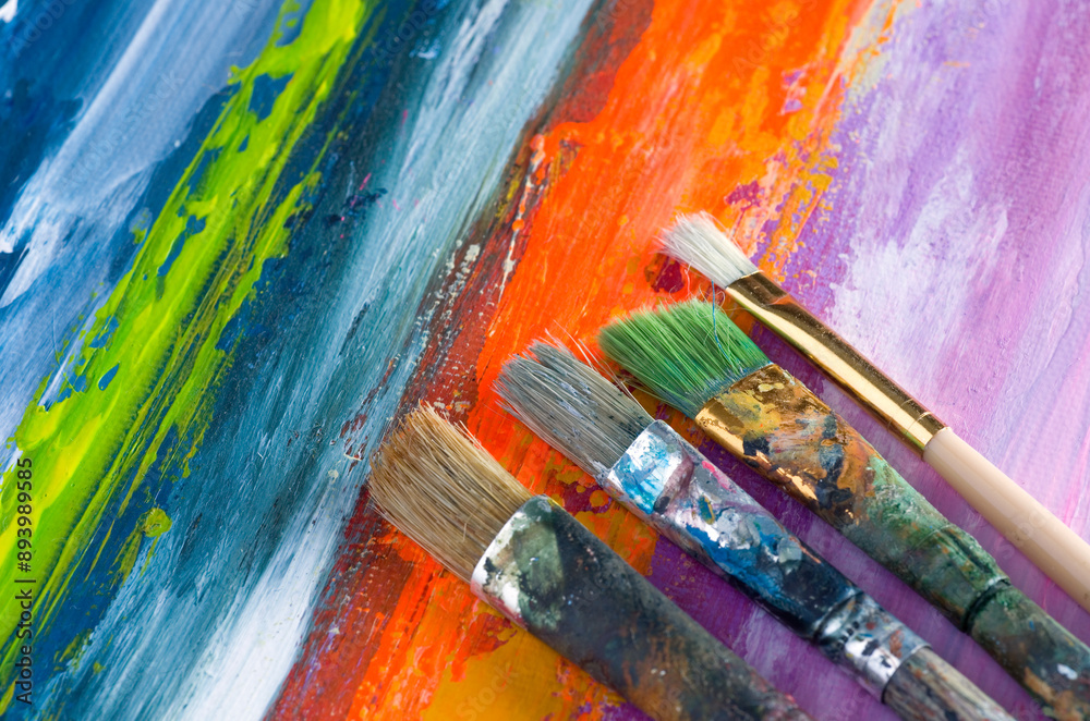Fototapeta premium Various Paint Brushes on Colorful Abstract Canvas Background
