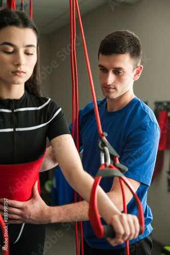 Supervised red cord physiotherapy at rehabilitation center. Pain-free red cord treatment of sport injury. Activating neuromuscular system with red cord equipment.