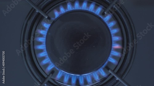 Kitchen burner turning on.Stove top burner igniting into a blue cooking flame.  Natural gas inflammation, close up, slow motion.
