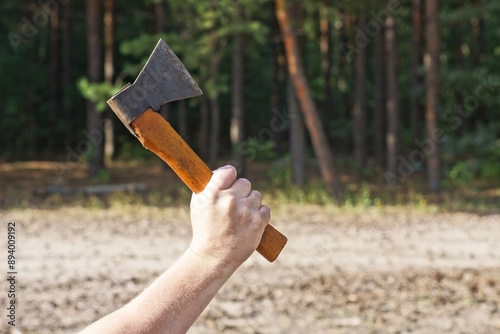 hand swinging one small brown black axe on the street