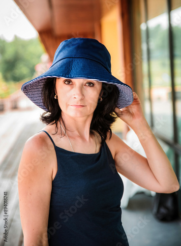 Fotografía 50 years old russian woman in short dress holding her hat on the sumer day