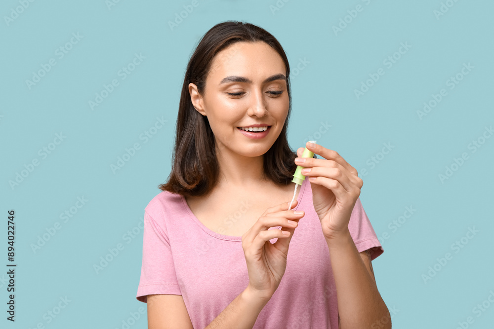 Beautiful young woman with tampon on blue background Beautiful young woman with tampon on blue background