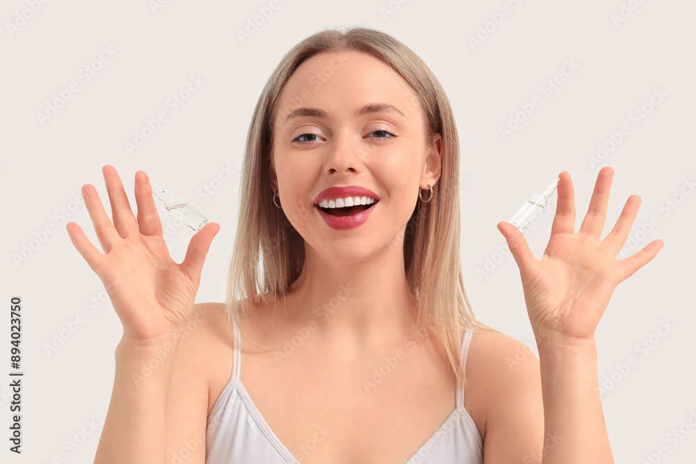 Beautiful young woman holding ampules on white background. Skin care concept Beautiful young woman holding ampules on white background. Skin care concept