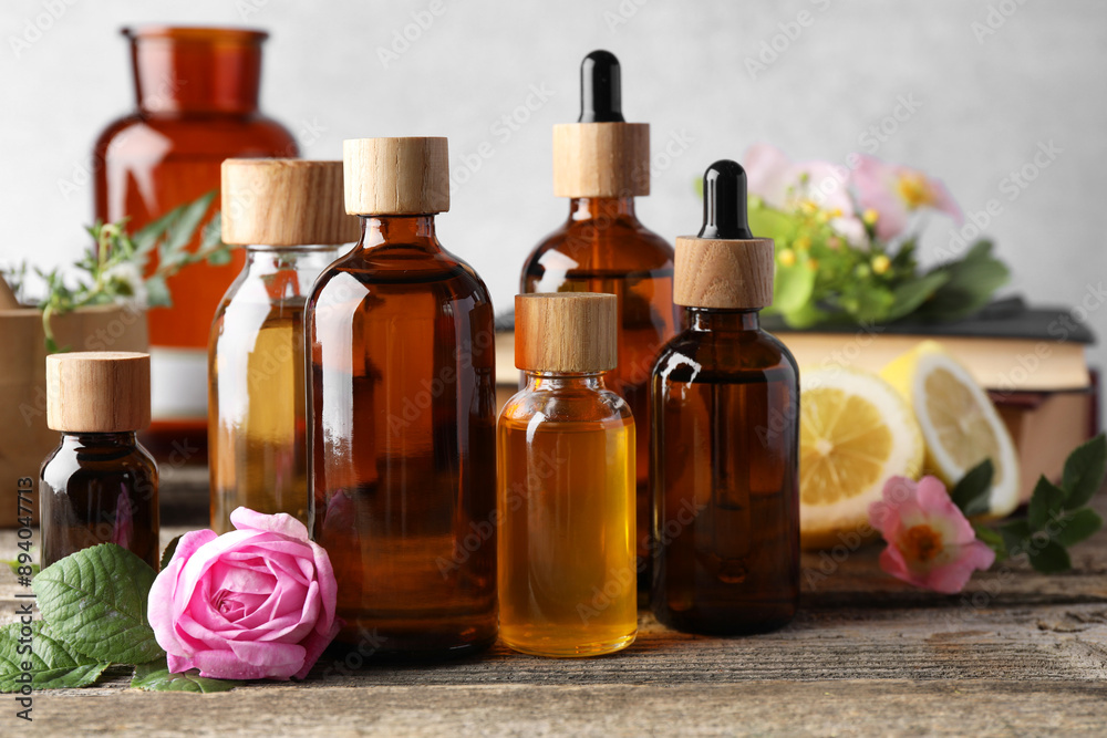Aromatherapy. Different essential oils and flowers on wooden table