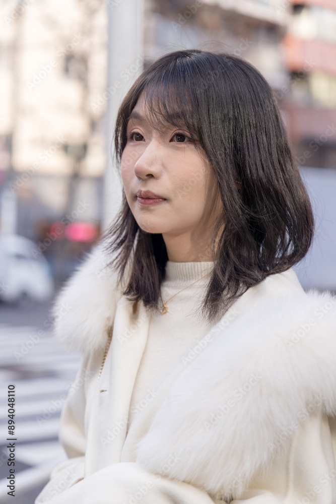 Twenty-something Chinese woman with black hair wearing a white coat with a fluffy fur hood and a white skirt walking on a public road in Minato, Tokyo, Japan. Twenty-something Chinese woman with black hair wearing a white coat with a fluffy fur hood and a white skirt walking on a public road in Minato, Tokyo, Japan.