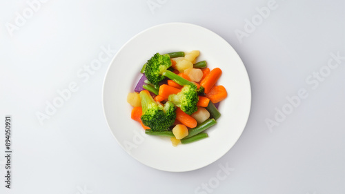 Steamed mixed vegetables including broccoli, carrots, and zucchini on a white plate, close-up view