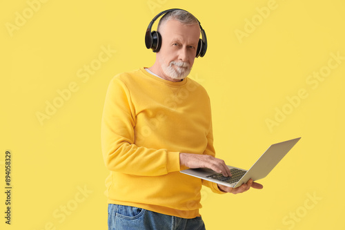 Mature man in headphones us...