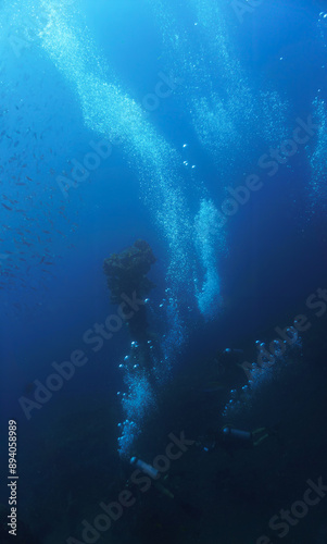 Wallpaper Mural Underwater photo of scuba divers in at the USS Liberty Shipwreck from World War Two, WWII. Dreamlike blue deep diving. From a scuba dive in Bali, Indonesia, Asia. Torontodigital.ca