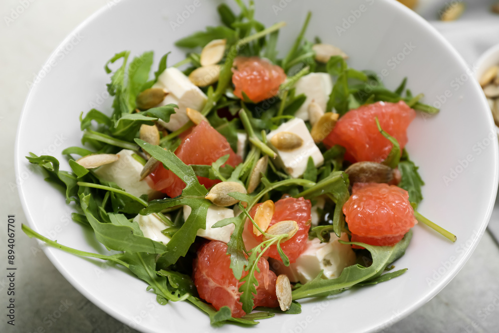 Bowl of healthy vegetable salad with arugula, grapefruit, feta cheese and pumpkin seeds, closeup Bowl of healthy vegetable salad with arugula, grapefruit, feta cheese and pumpkin seeds, closeup