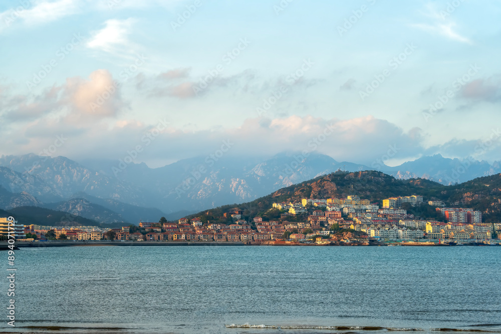 Fototapeta premium Scenic Coastal View with Mountains and Cityscape at Sunset