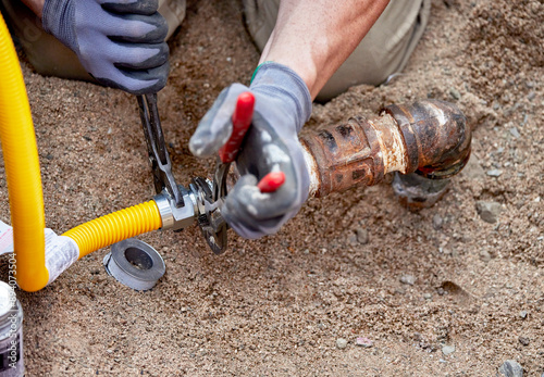 A Plumber hooking up a temporary gas line to a propane tank