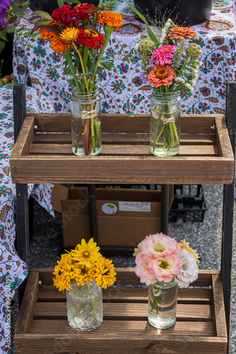 Marigolds, Zinnias, Statice, Gold Coneflowers and PIck Corelli flowers in glass vases photo