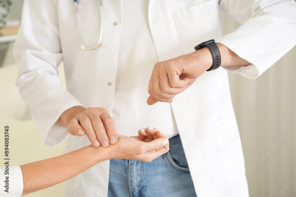 Φωτογραφία Male doctor with smartwatch checking mature woman's pulse in clinic, closeup