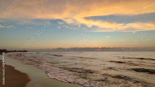 Wallpaper Mural Dawn sunset sunrise on sea. The red light of dawn reflected by clouds in the blue sky and the surface of sea water. Waves rolling onto sandy beach of seashore. Torontodigital.ca