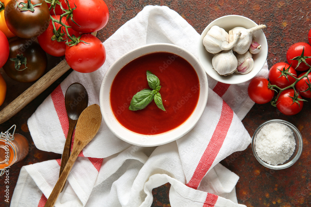 Bowl of fresh tomato soup with fresh vegetables and garlic on dark background Bowl of fresh tomato soup with fresh vegetables and garlic on dark background