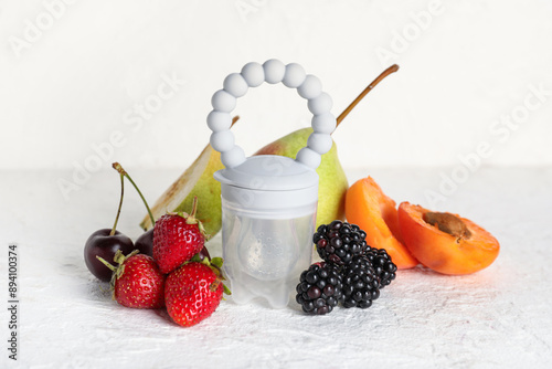 Fototapeta Naklejka Na Ścianę i Meble -  Composition with baby nibbler and ripe fruits on light background