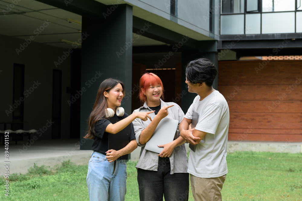 Obraz premium Group of Diverse Students Socializing Outdoors on Campus with Laptops and Headphones