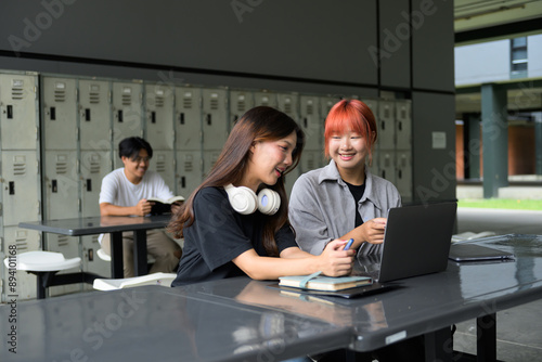 Group of Diverse Students Studying Together in Modern School Campus with Laptops and Notebooks