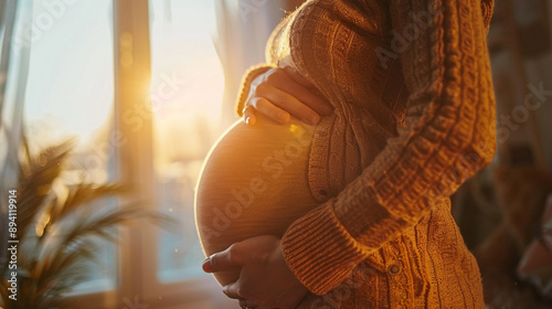 pregnant woman's belly with a focus on another woman's hand gently resting on it, symbolizing support, care, and the bond between friends or family during pregnancy