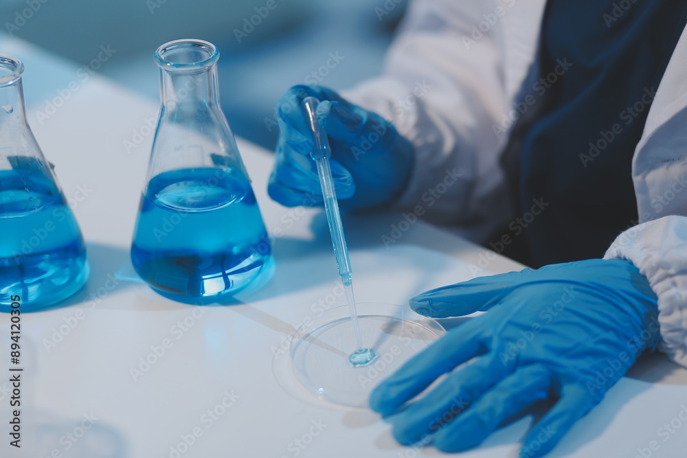 Group of dedicated scientist conduct chemical experiment in medical laboratory, carefully drop precise amount of liquid from pipette into test tube for vaccine drug or antibiotic development. Neoteric Group of dedicated scientist conduct chemical experiment in medical laboratory, carefully drop precise amount of liquid from pipette into test tube for vaccine drug or antibiotic development. Neoteric