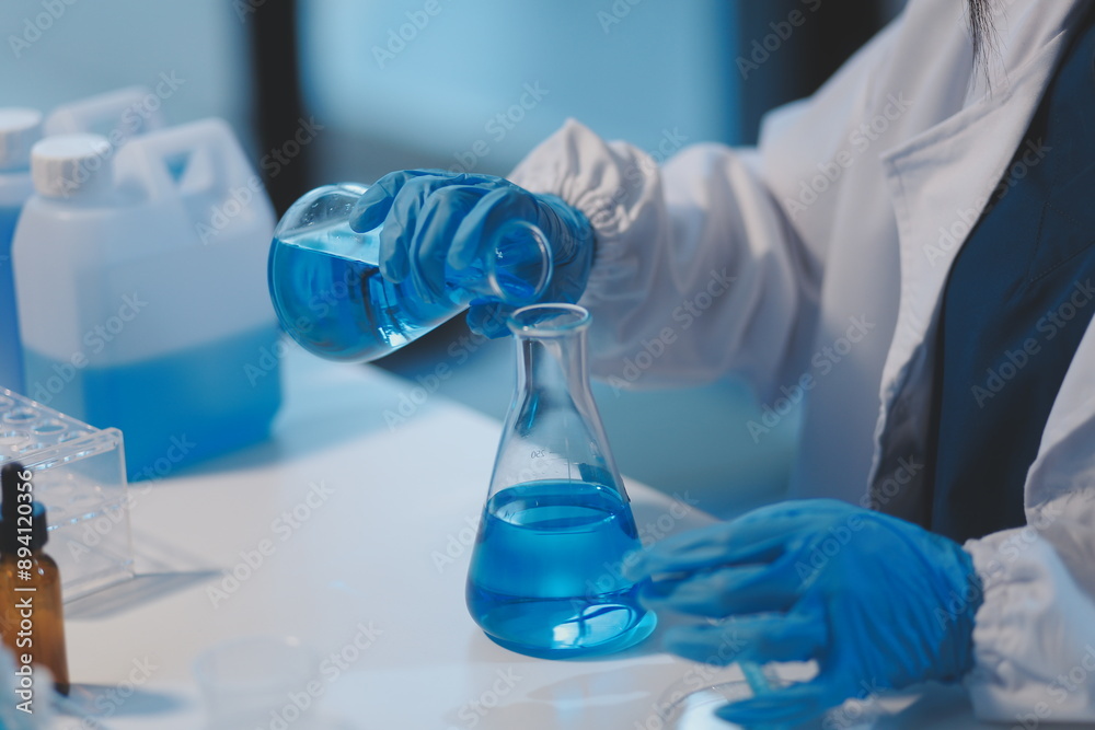 Fototapeta premium Group of dedicated scientist conduct chemical experiment in medical laboratory, carefully drop precise amount of liquid from pipette into test tube for vaccine drug or antibiotic development. Neoteric