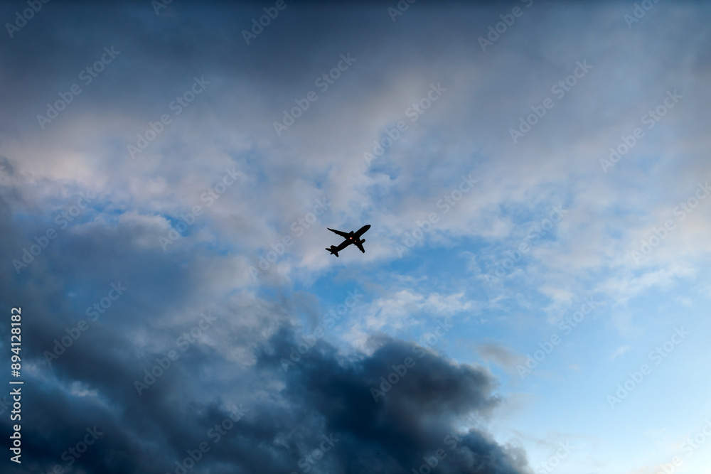 silhouette airplane fly in blue sky with clouds