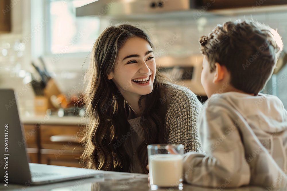 siblings laughing together at a kitchen table, laptop and glass of milk nearby, warm and joyful family moment siblings laughing together at a kitchen table, laptop and glass of milk nearby, warm and joyful family moment