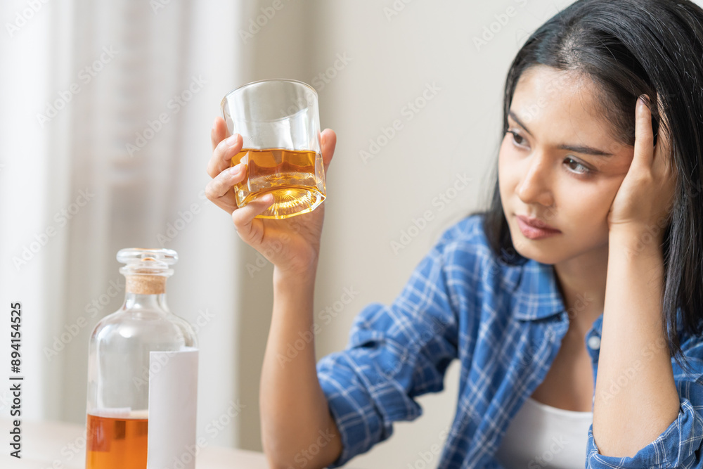 Alcoholism drunk asian young woman hand holding glass of alcohol or whiskey, female sitting alone, drinking on table at home, at night. Treatment of alcohol addiction, suffer abuse problem alcoholism Alcoholism drunk asian young woman hand holding glass of alcohol or whiskey, female sitting alone, drinking on table at home, at night. Treatment of alcohol addiction, suffer abuse problem alcoholism