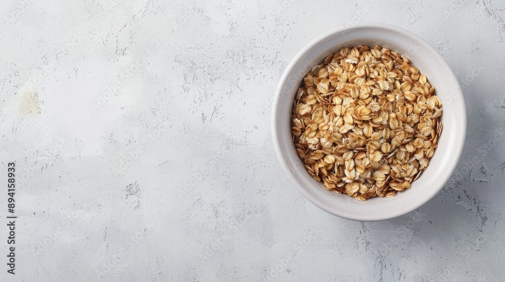 Oats in white bowl on plain background with space for text Oats in white bowl on plain background with space for text