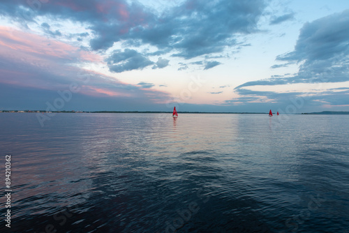 Red sailboat at sea sunset