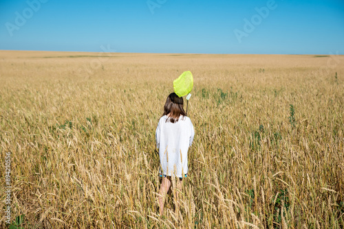 A girl in a wheat field with a net