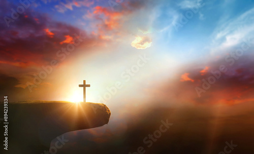 Картината върху платно Cross on the cliff and sunset sky background.