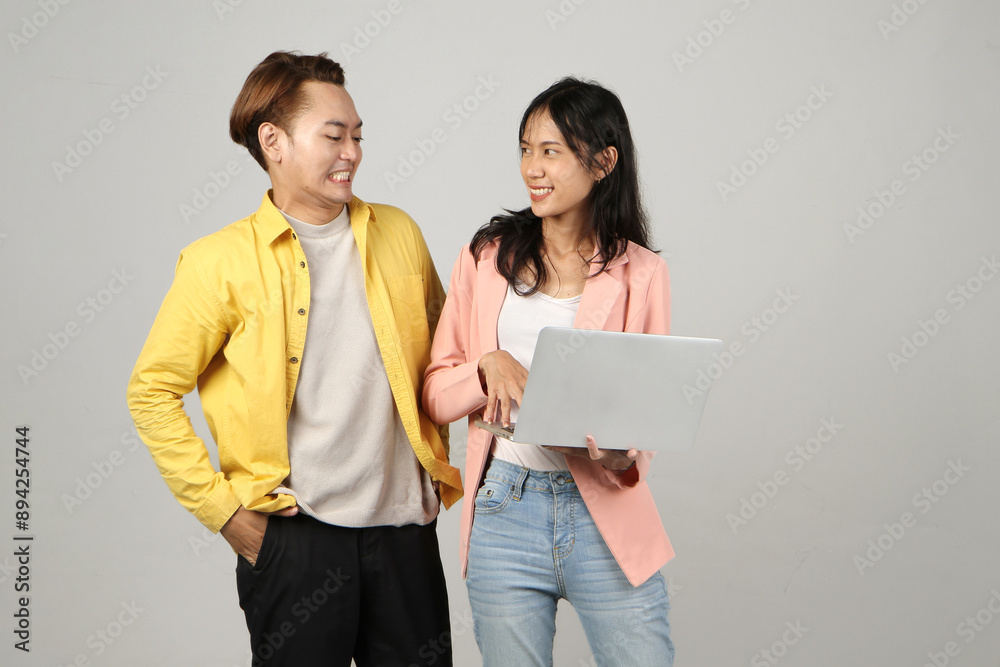 portrait of angry mad asian Indonesian couple holding laptop computer on isolated background