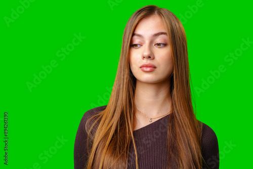 Young Woman With Long Brown Hair Looking Down in Studio Setting