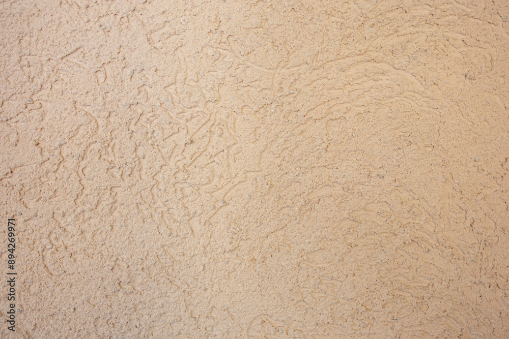 Abstract grained stucco texture , beige painted cement plaster on a house exterior wall, empty patterned backdrop Abstract grained stucco texture , beige painted cement plaster on a house exterior wall, empty patterned backdrop