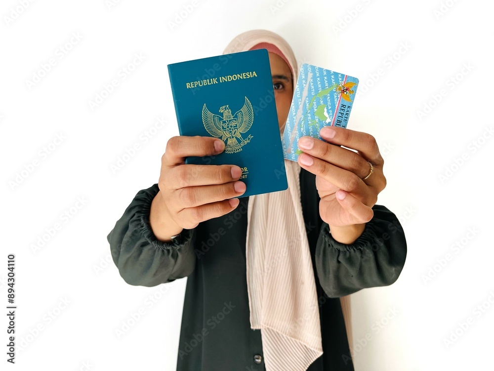 © Siti Fatonah - A blurred woman holding Indonesian Passport and Indonesian identity cards (KTP) isolated on white background © Siti Fatonah - A blurred woman holding Indonesian Passport and Indonesian identity cards (KTP) isolated on white background