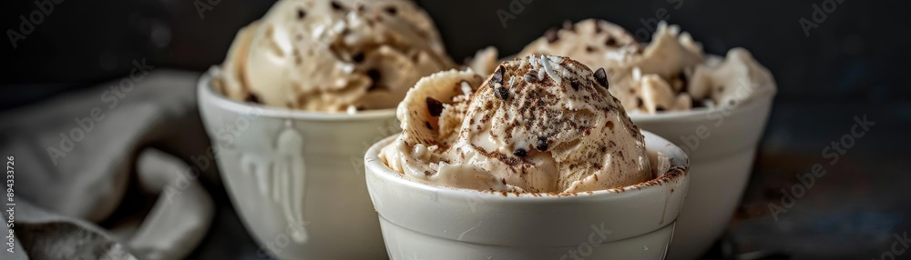 Delicious scoops of creamy ice cream in white bowls, garnished with chocolate shavings, perfect for a sweet treat. Dark background. Delicious scoops of creamy ice cream in white bowls, garnished with chocolate shavings, perfect for a sweet treat. Dark background.