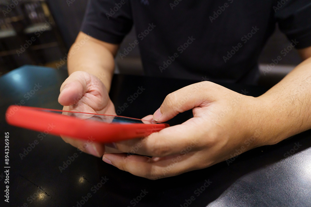 Obraz premium Man playing game on mobile phone. gamer boy playing video games holding Smartphone&nbsp;working mobile devices. cell telephone technology e-commerce concept.