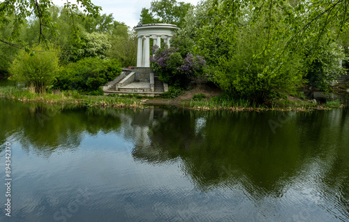 A white stone gazebo on the lake shore.