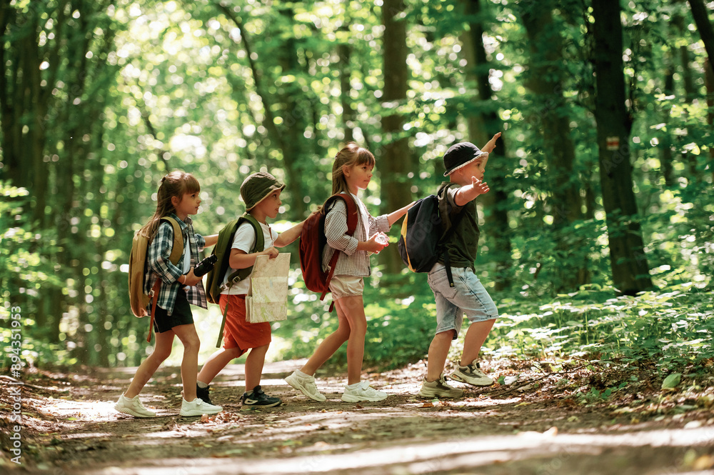 Going to the side. Kids in forest at summer daytime together Going to the side. Kids in forest at summer daytime together
