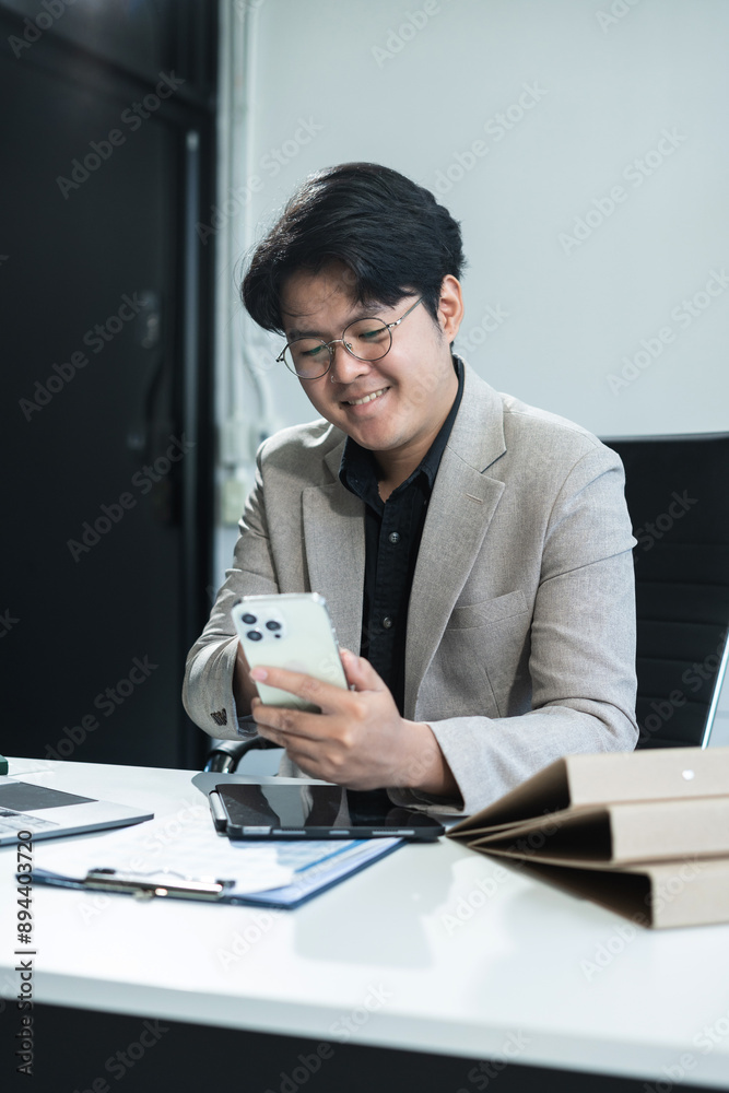 Business man working at office with smartphone and documents on desk, financial adviser analyzing data. Business man working at office with smartphone and documents on desk, financial adviser analyzing data.