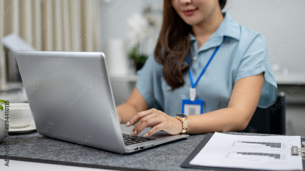 A close-up image of an Asian businesswoman is working on her laptop, typing on the laptop keyboard. A close-up image of an Asian businesswoman is working on her laptop, typing on the laptop keyboard.