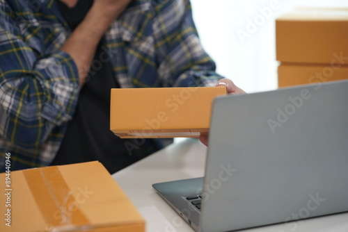 Starting a small business, business owner writes address on a cardboard box, small business entrepreneur, SME working with boxes at home, selling online, close-up photo