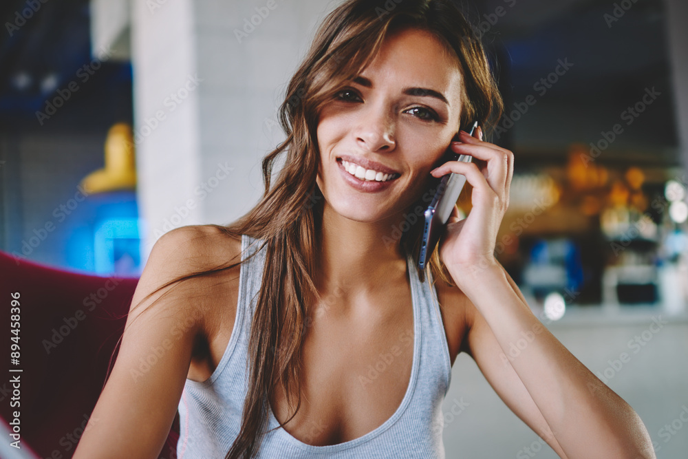 Portrait of cheerful hipster girl smiling at camera while making notes and calling on smartphone device.Positive young woman laughing during mobile conversation on cellular in cafe interior Portrait of cheerful hipster girl smiling at camera while making notes and calling on smartphone device.Positive young woman laughing during mobile conversation on cellular in cafe interior