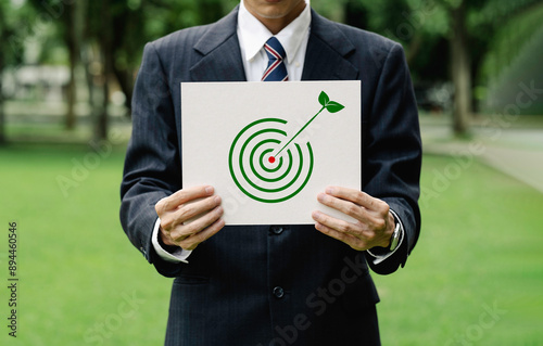 Business hands holding a sign environment target of Green business, Business Development Strategies with Environmental Conservation.
