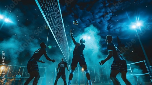 Professional volleyball players in action on the night court.  photo