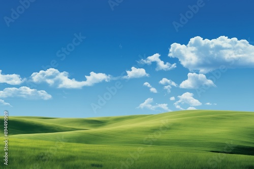 A beautiful summer or spring landscape with green grass on the hills and green fields. The blue sky is filled with white clouds and bright sunlight. Nature as a background. © soleg
