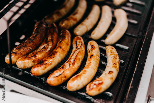 Close-up of delicious sausages grilling on a barbecue, focus in the middle.