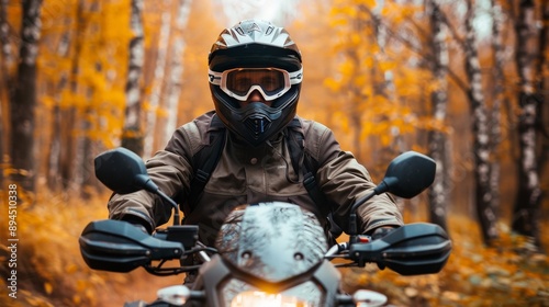 Motorrad im Wald im Herbst. Geländemotorrad fährt durch ein Waldgebiet mit braunen Blättern.  photo