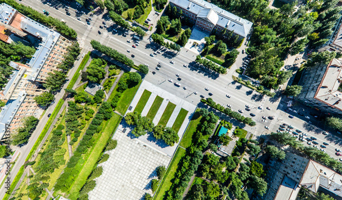 Aerial city view with crossroads, roads, houses, buildings, parks and parking lots. Copter drone helicopter shot. Panoramic wide angle image.